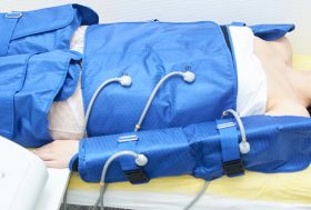 mujer tumbada en camilla en sesión de presoterapia