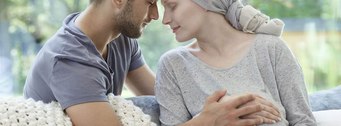 ¿Cómo tratar el cáncer estando embarazada? Cáncer en el embarazo: pareja con las manos enlazadas enlazadas , mujer embarazada y con pañuelo en la cabeza