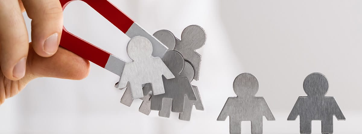 química del amor ¿Qué es la química del amor?: manos cogiendo un imán y siluetas en papel de muñecos
