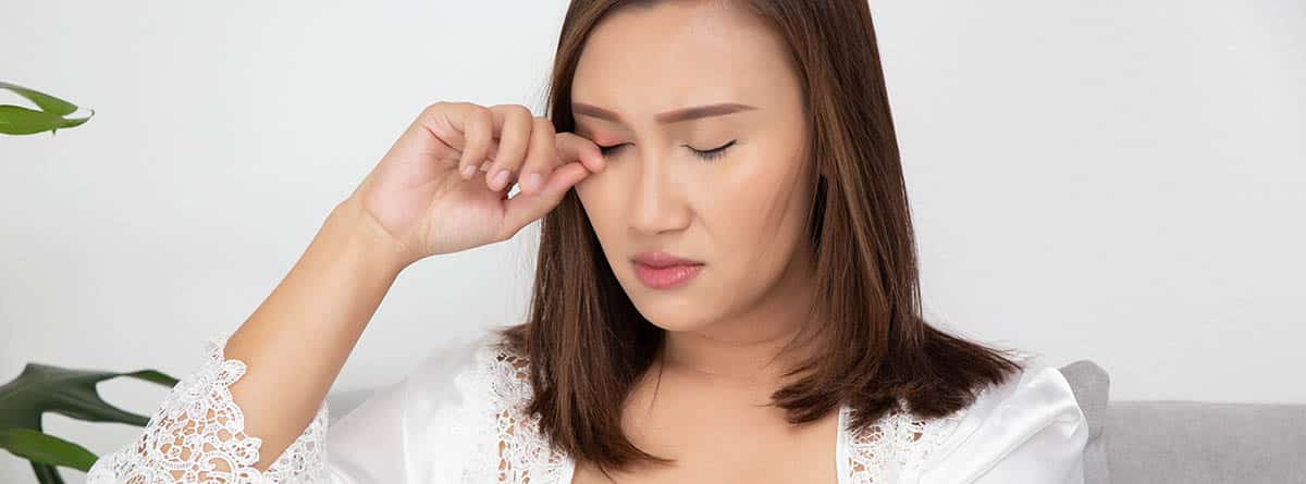 mujer rascándose el ojo por una molestia