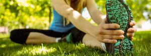 Mujer joven estirando en el parque