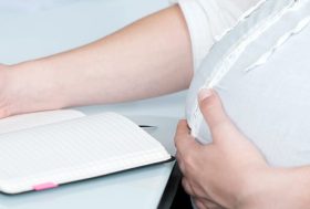 Mujer embarazada con una libreta