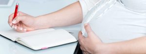 Mujer embarazada con una libreta