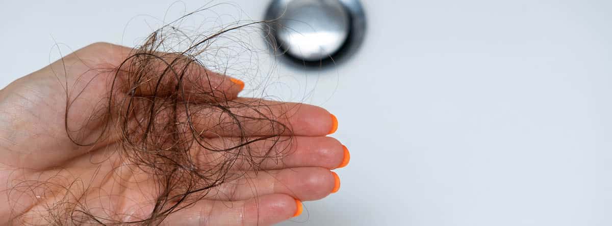 Cabello caído de mujer en grifo