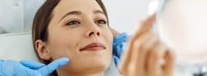 Mujer sonriente recibiendo un tratamiento de bioestimuladores de colágeno