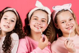 Tres niñas con productos de cosmética para adultos