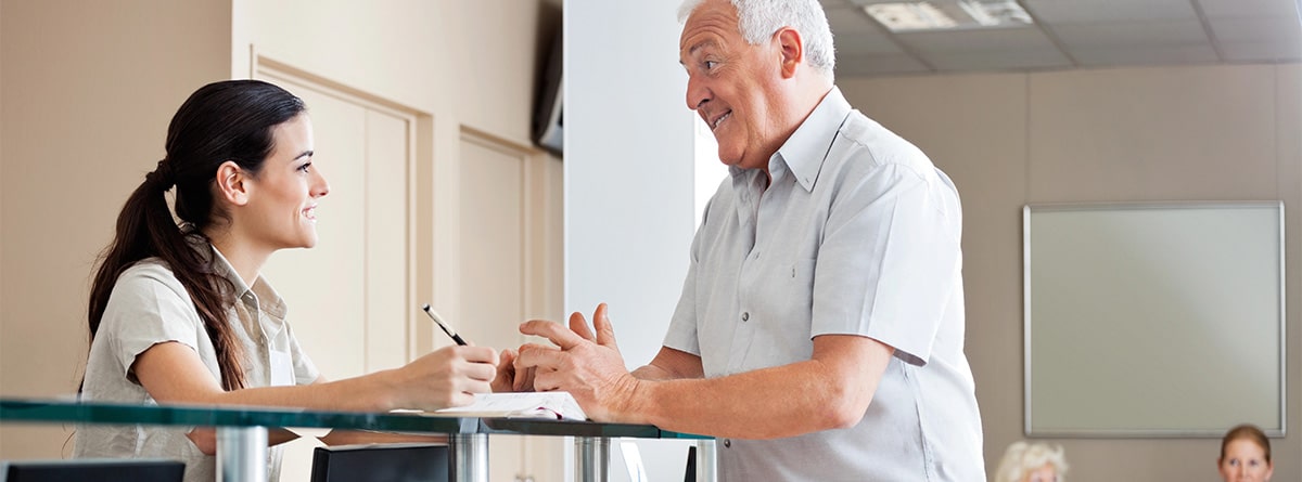 Hombre mayor en la recepción de un centro de salud